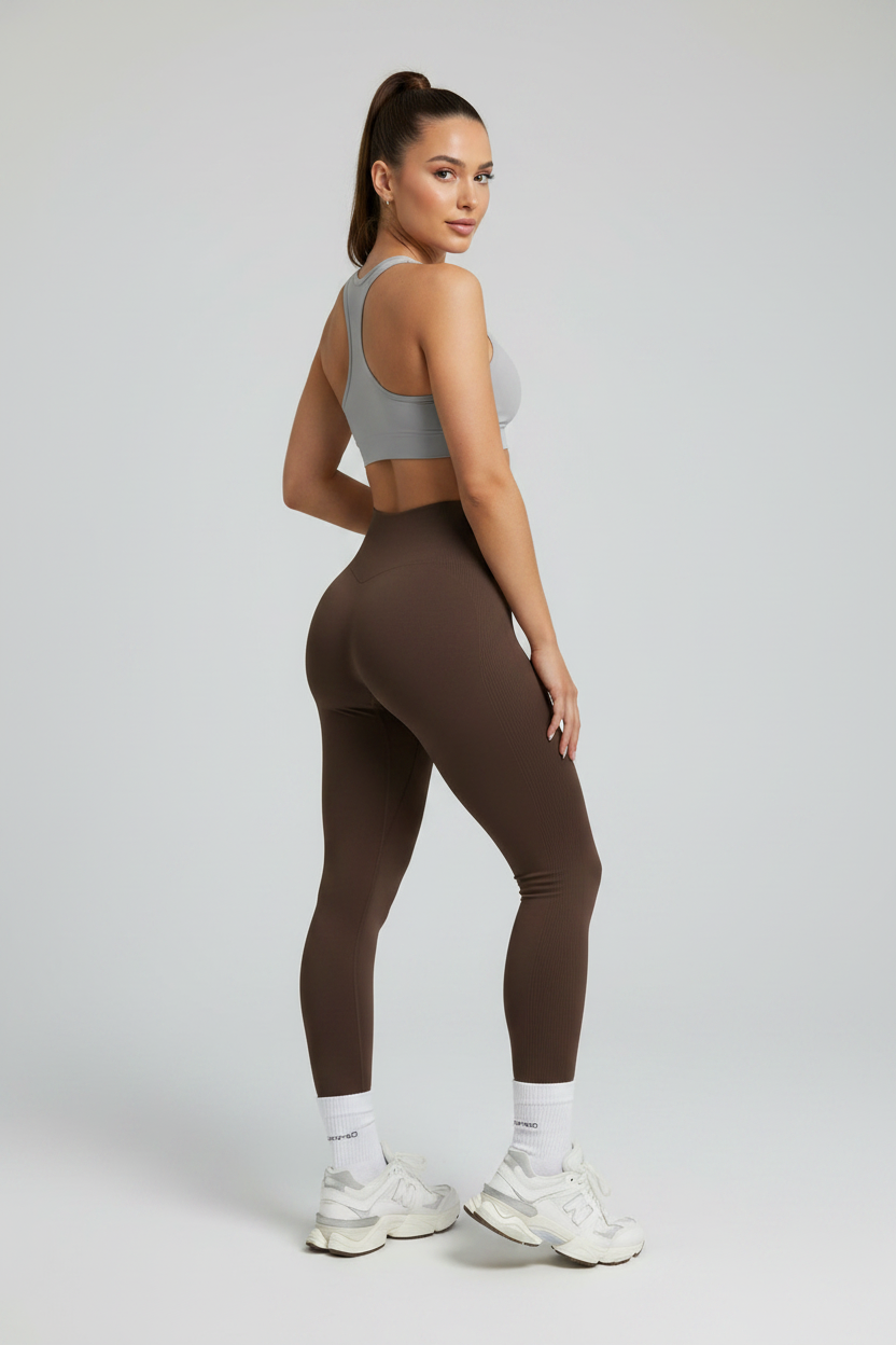 Woman wearing espresso PowerForm Legging, looking over shoulder